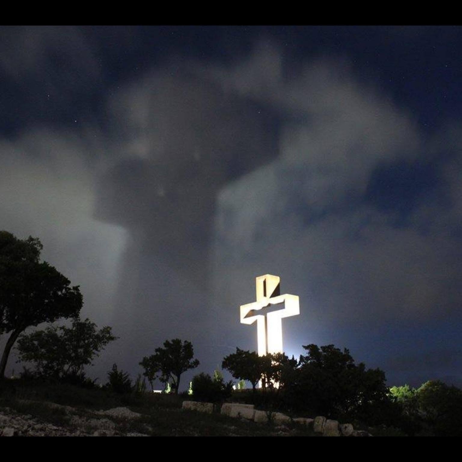 An illuminated cross against a night sky